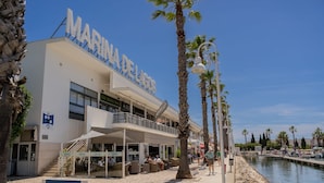 A waterfront hotel with a prominent sign, outdoor seating, and a poolside area. - Exquisite Apartment on the Lagos Marina - Marina Retreat (Lagos)