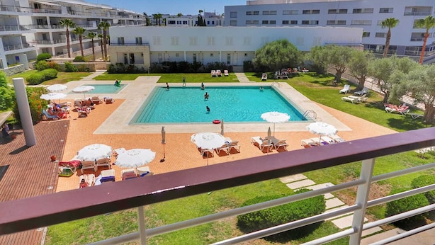 A hotel with a swimming pool, sun loungers, and a view of the surrounding buildings. - Exquisite Apartment on the Lagos Marina - Marina Retreat (Lagos)