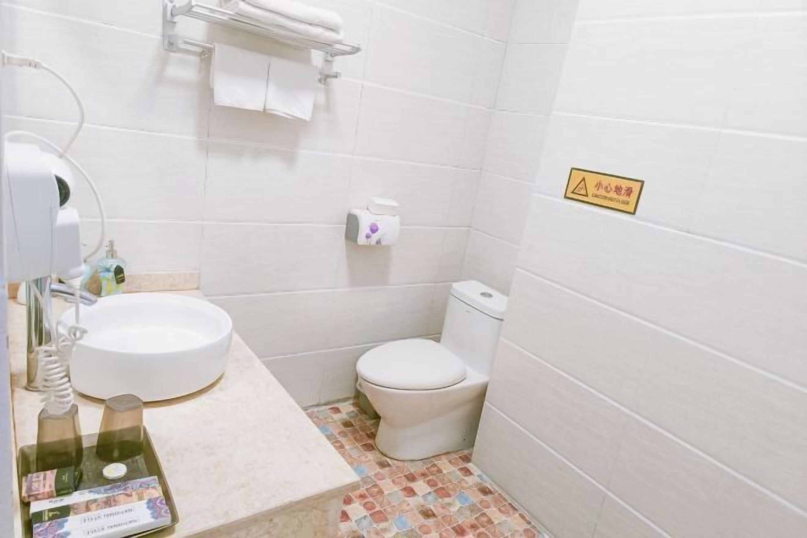A small bathroom with a toilet, sink, and a towel rack.