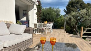 En soffa av rotting och ett glasbord med två glas fyllda med dryck.
