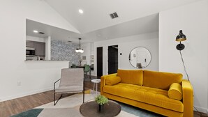 Un salon moderne avec un canapé jaune moutarde, une table basse ronde et un design minimaliste.