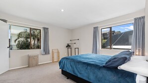 Quarto com uma cama, mesa de cabeceira, janela e vista para o exterior.