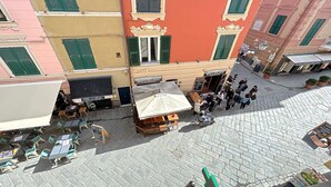 A courtyard with outdoor seating, a café, and a sign for "Caffè del Colosso".