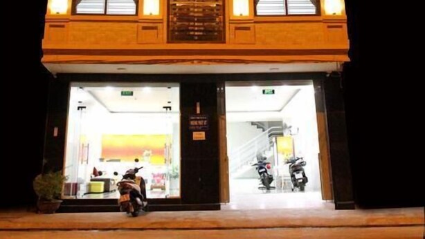A hotel named Callsea Nha Trang with illuminated signage, a visible entrance, and a scooter parked outside. - Call Sea Nha Trang  (Nam Nha Trang)