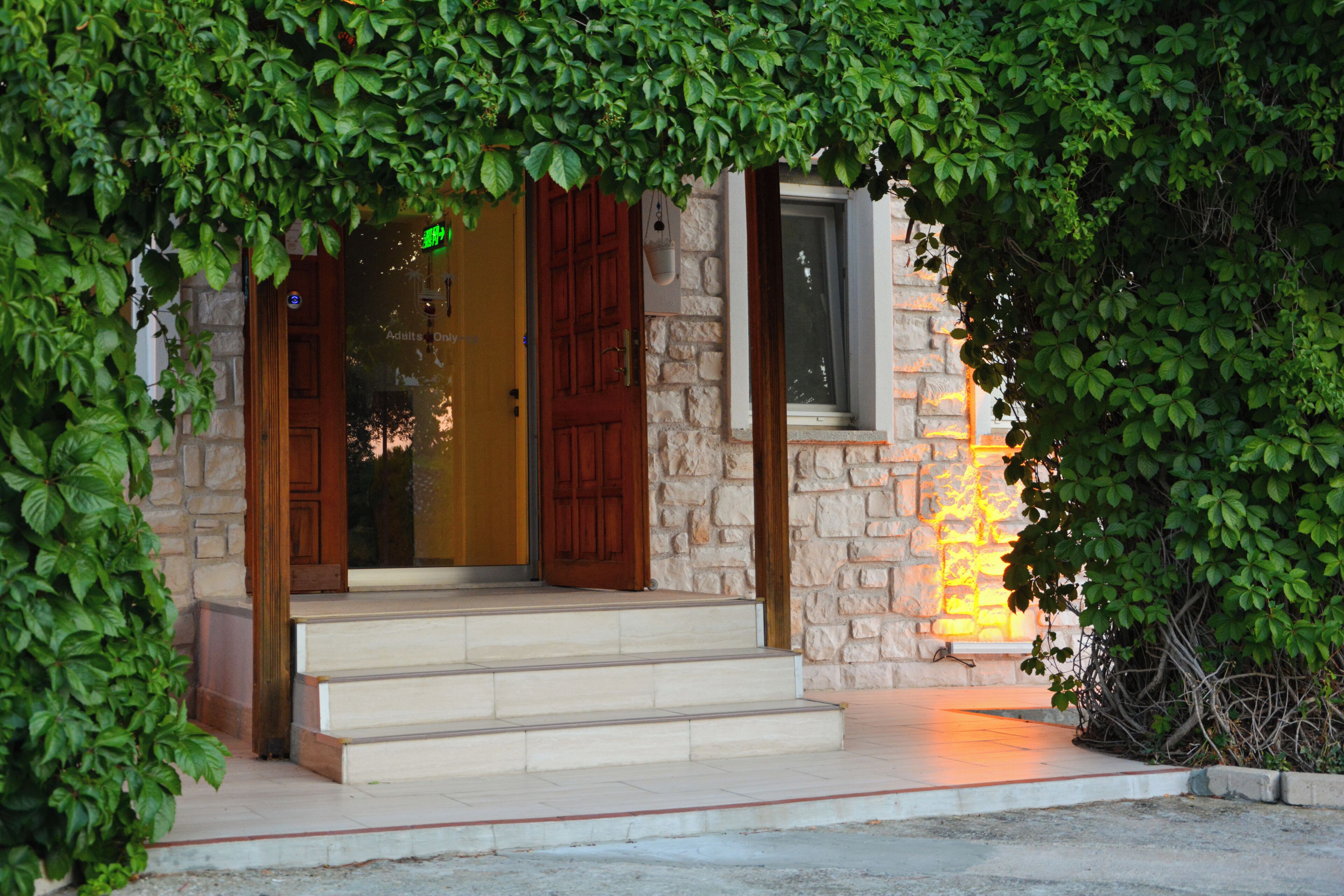A stone building with a wooden door and steps leading to the entrance.