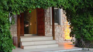 A stone building with a wooden door and steps leading to the entrance.
