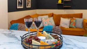 A marble table with a cheese and wine board, a sofa with colorful cushions, and a dark wall with framed pictures. - All Ensuite,smarttvs,garden,20 Mins to Nec,parking (Coventry)
