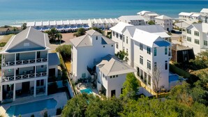 Ein Resort mit mehreren weißen Gebäuden, einem Swimmingpool und Blick auf den Ozean.