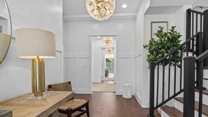 Ein modernes Interieur mit einem Holzespeisetisch, einer Lampe und einer Treppe.