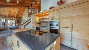 A modern kitchen with wooden cabinetry, a granite countertop, and stainless steel appliances.