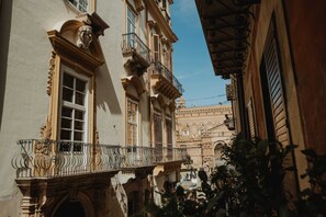 A narrow street with ornate balconies and a clear blue sky. - Ambrosia-Timeless Hosting (Palermo)