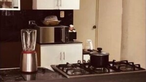 A modern kitchen with a gas stove, a blender, a microwave, and white cabinets. - 3 bedroom apartment in los olivos (Los Olivos)