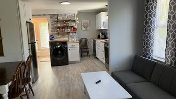 Un espacio habitable compacto con kitchenette, comedor y zona de estar.
