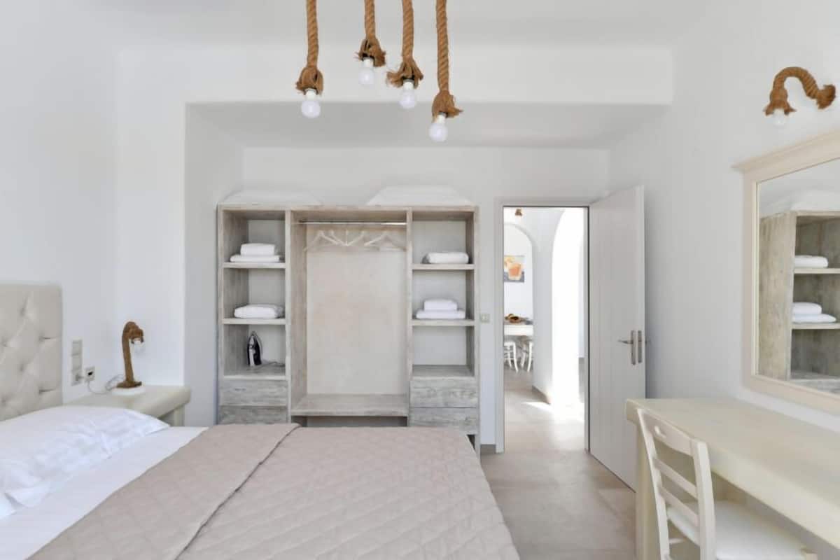 Un dormitorio moderno con una cama grande, un escritorio y un vestidor.
