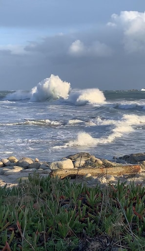 A rocky shoreline with waves crashing onto the beach.