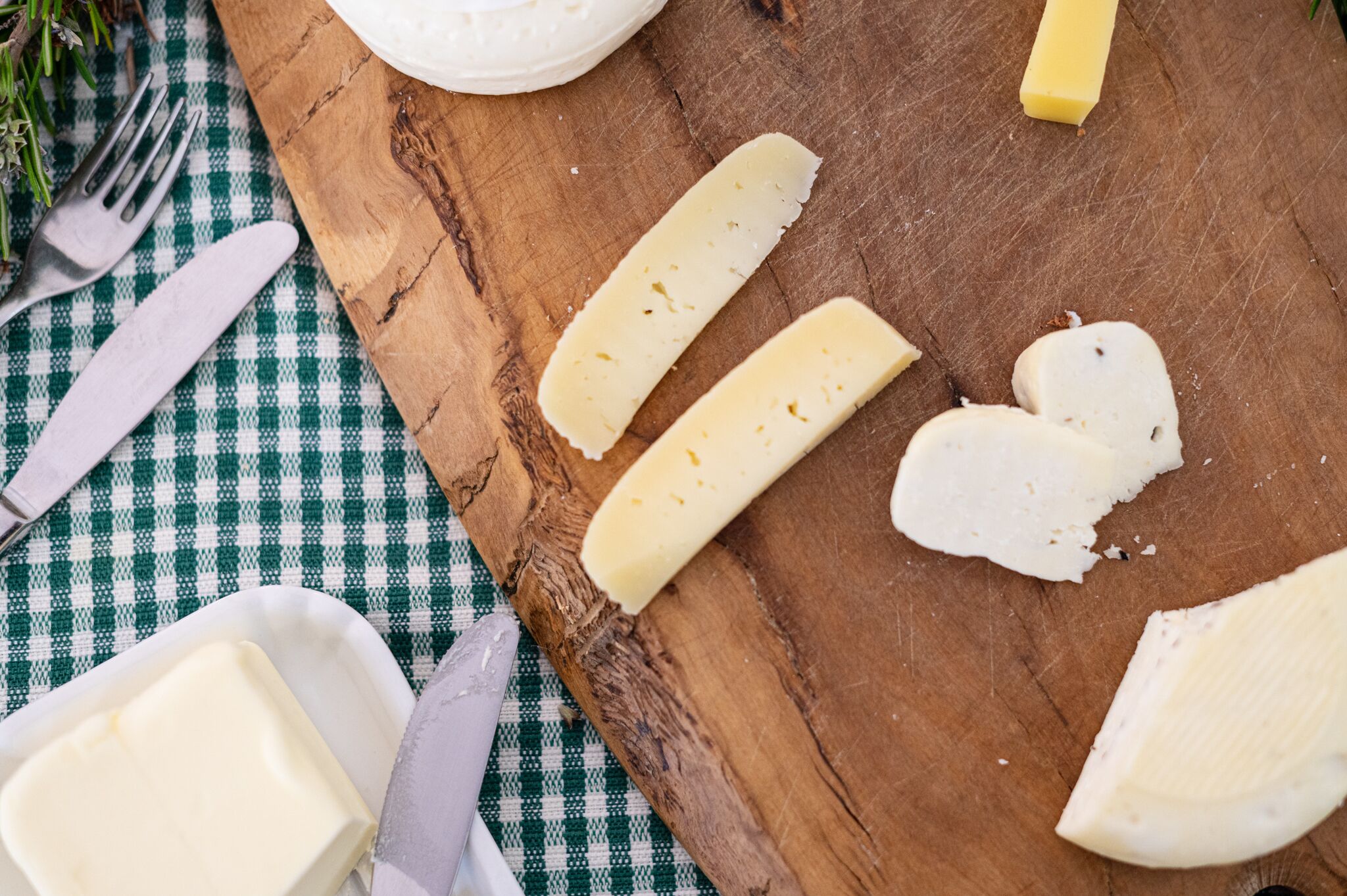 Une planche à découper en bois avec des tranches de fromage et un couteau.