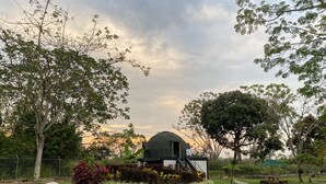 A garden with a stone pathway, a small dome structure, and surrounding trees. - Hotel Zensi 420 (Lejanías)