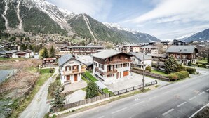A residential area with houses, a road, and snow-capped mountains in the background. - Kotibe- Lovely apartment in Chamonix (Chamonix-Mont-Blanc)