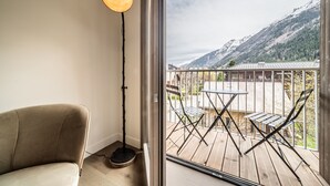 Ett rum med utsikt över en balkong, en soffa och en golvlampa.