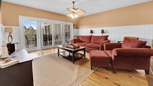 A living room with a sofa set, a coffee table, and a ceiling fan.
