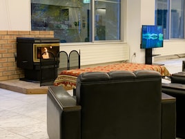 A cozy room with a fireplace, a bed with a patterned bedspread, and a television on a stand.