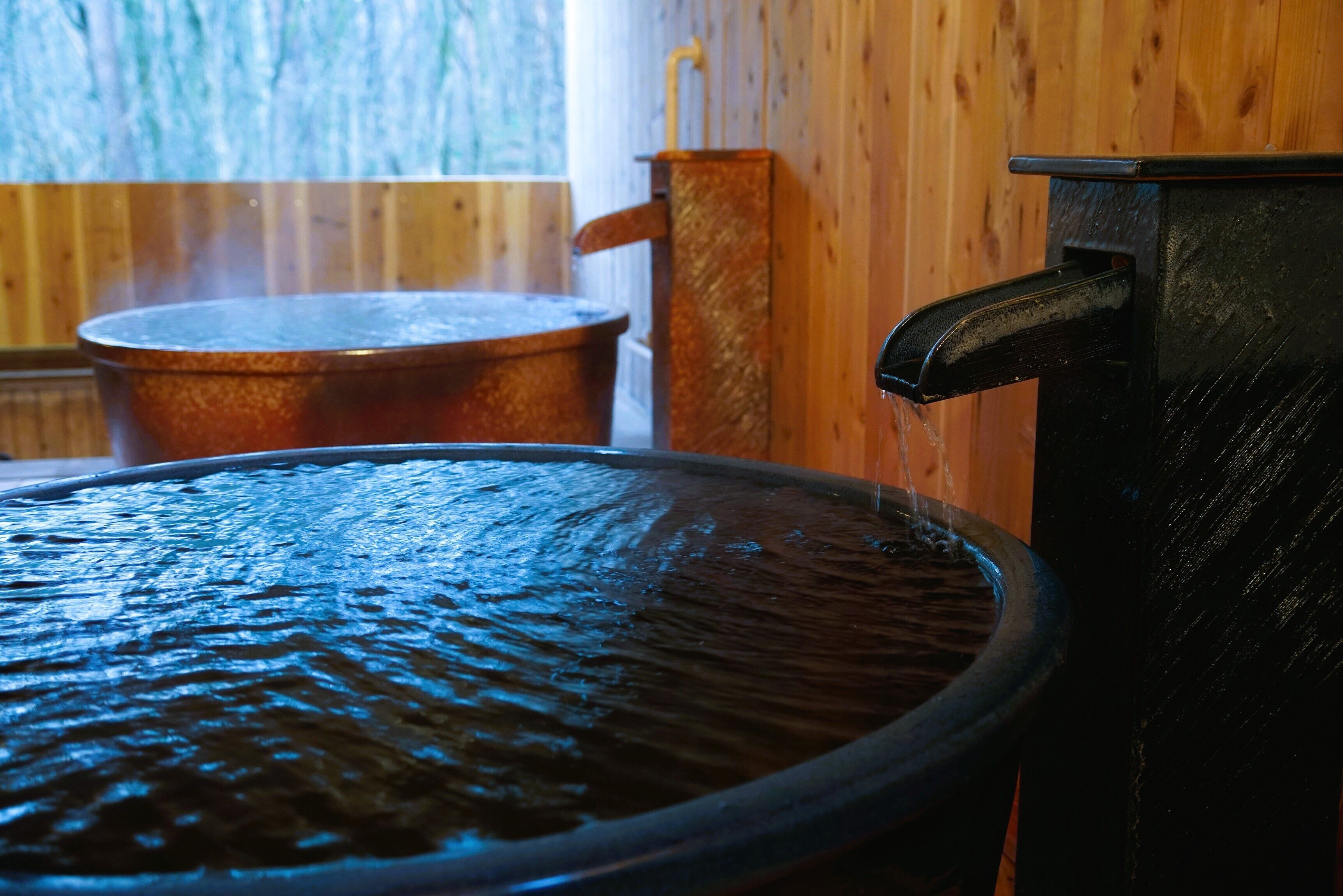 A hot tub with a wooden wall in the background.