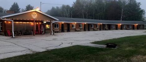 A motel with a row of rooms, a covered front area, and a parking lot.