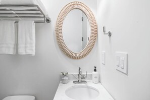 Een bad,  milieuvriendelijk toiletgerief, een haardroger, handdoeken