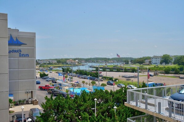 Um hotel com estacionamento, piscina e vista para um porto de iates.