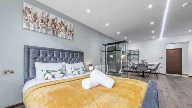 Una habitación de hotel moderna con una cama grande, un escritorio y una silla.