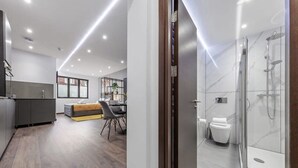 Un baño moderno con cabina de ducha de vidrio y un inodoro.