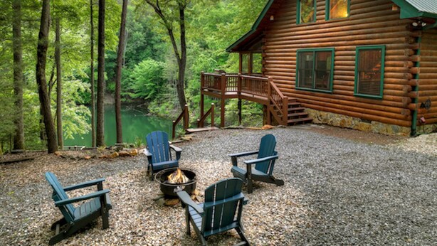 Eine Blockhütte mit einer Veranda und einem Sitzbereich im Freien.