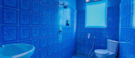 Un baño con azulejos azules, un lavabo blanco y un inodoro.