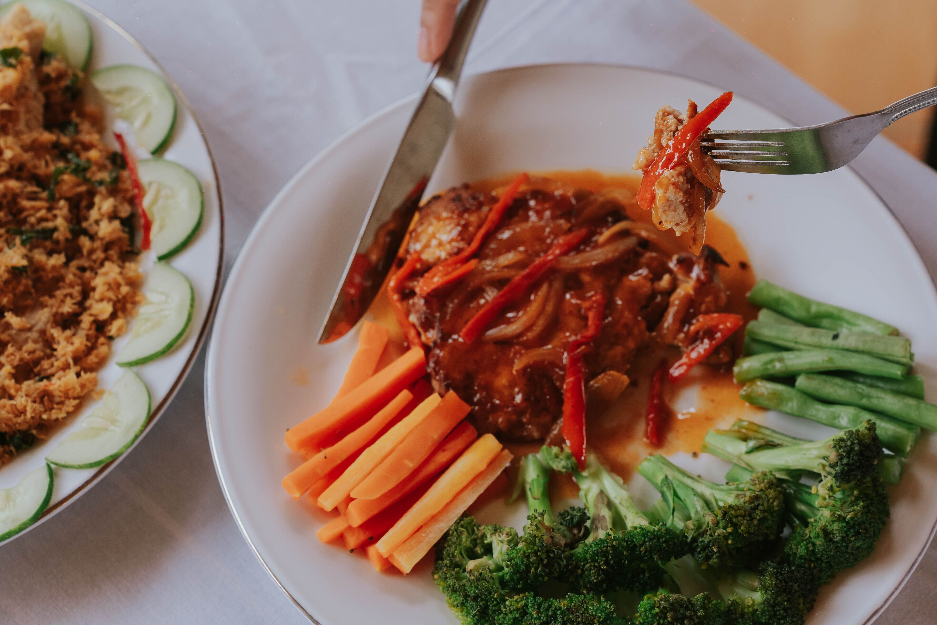 A plate of food with meat, vegetables, and a fork.