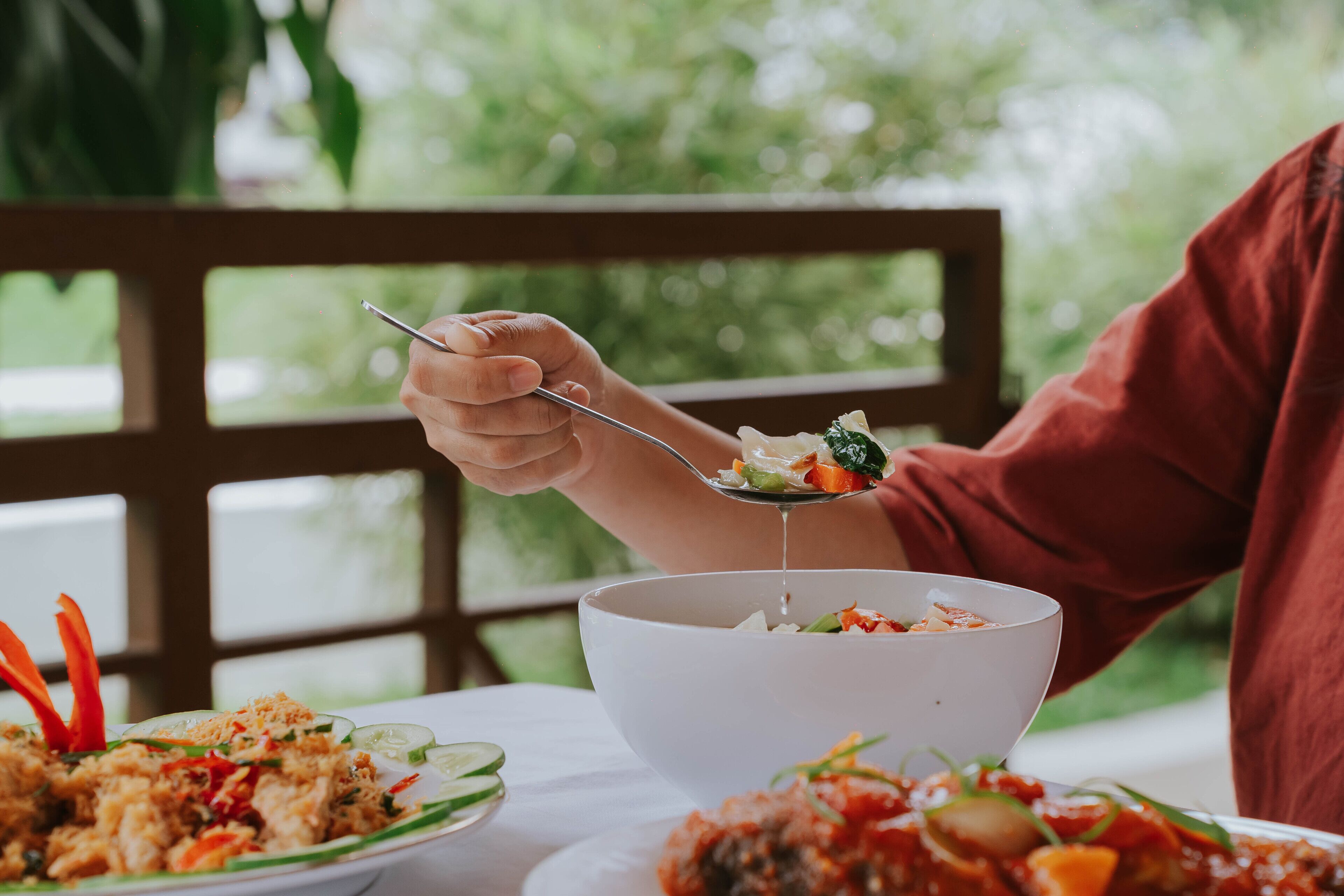 A dining table with a white bowl and plates of food.