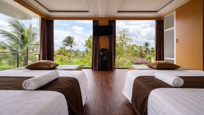A hotel room with two beds, a TV, and a view of palm trees. - Nirvana Hotel Resort Tetebatu (Tetebatu)
