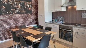 A modern kitchen with white cabinets, a stainless steel range hood, and a blackboard menu.
