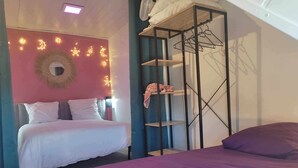 A bedroom with a bed, a wardrobe, and a wall decorated with lights.