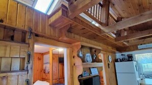 A wooden cabin interior with a loft bedroom, a kitchenette, and a dining area. - Cottage 200ft From Beach and Boardwalk ! (Hampton)