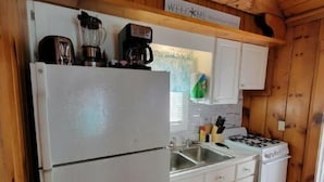 A compact kitchen with a refrigerator, stove, sink, and wooden cabinets. - Cottage 200ft From Beach and Boardwalk ! (Hampton)