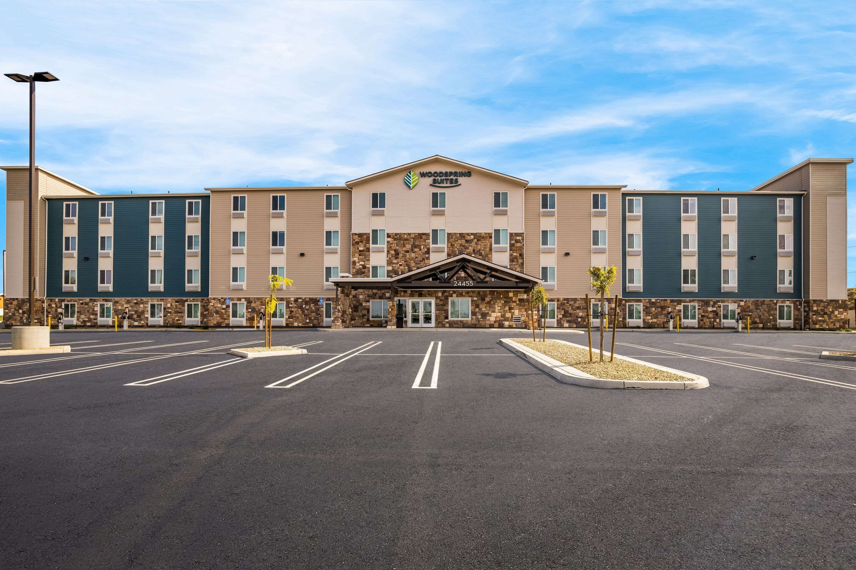 L’hôtel Woodperring Suites possède une entrée principale, un parking et offre une vue sur un ciel dégagé.