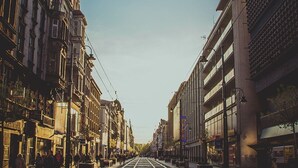 A street with tram tracks, buildings on either side, and pedestrians. - Silesia City Center Shopping Mall – 2,6 km (Katowice)
