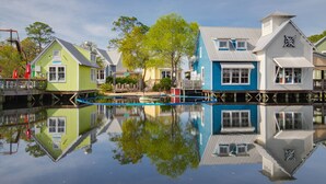 A waterfront property with multiple buildings, including a green house and a blue house, connected by a dock. - Westwinds 4786 (Miramar Beach)