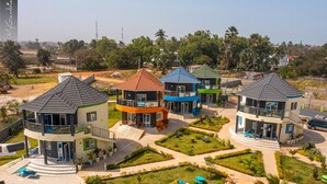 A residential complex with multiple two-story houses, each featuring a balcony and a small garden area. - Lovely 13-bed Complex on Cape Point Beach, Bakau - Bojang River Lodge (Bakau)