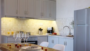 A modern kitchen with light-colored cabinets, a wooden countertop, and a stainless steel refrigerator. - Superior Two-Bedroom Villa (Lefkada)