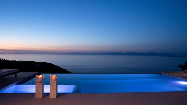 An infinity pool with a view of the sea at dusk. - Superior Two-Bedroom Villa (Lefkada)