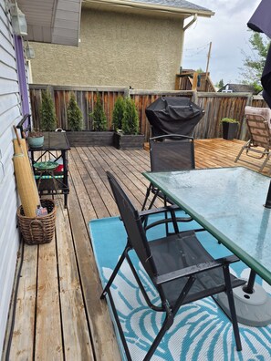 A wooden deck with outdoor furniture, a grill, and potted plants. - Beach Retreat with Hot Tub | 1 Block to Beach | Free Parking (Sylvan Lake)