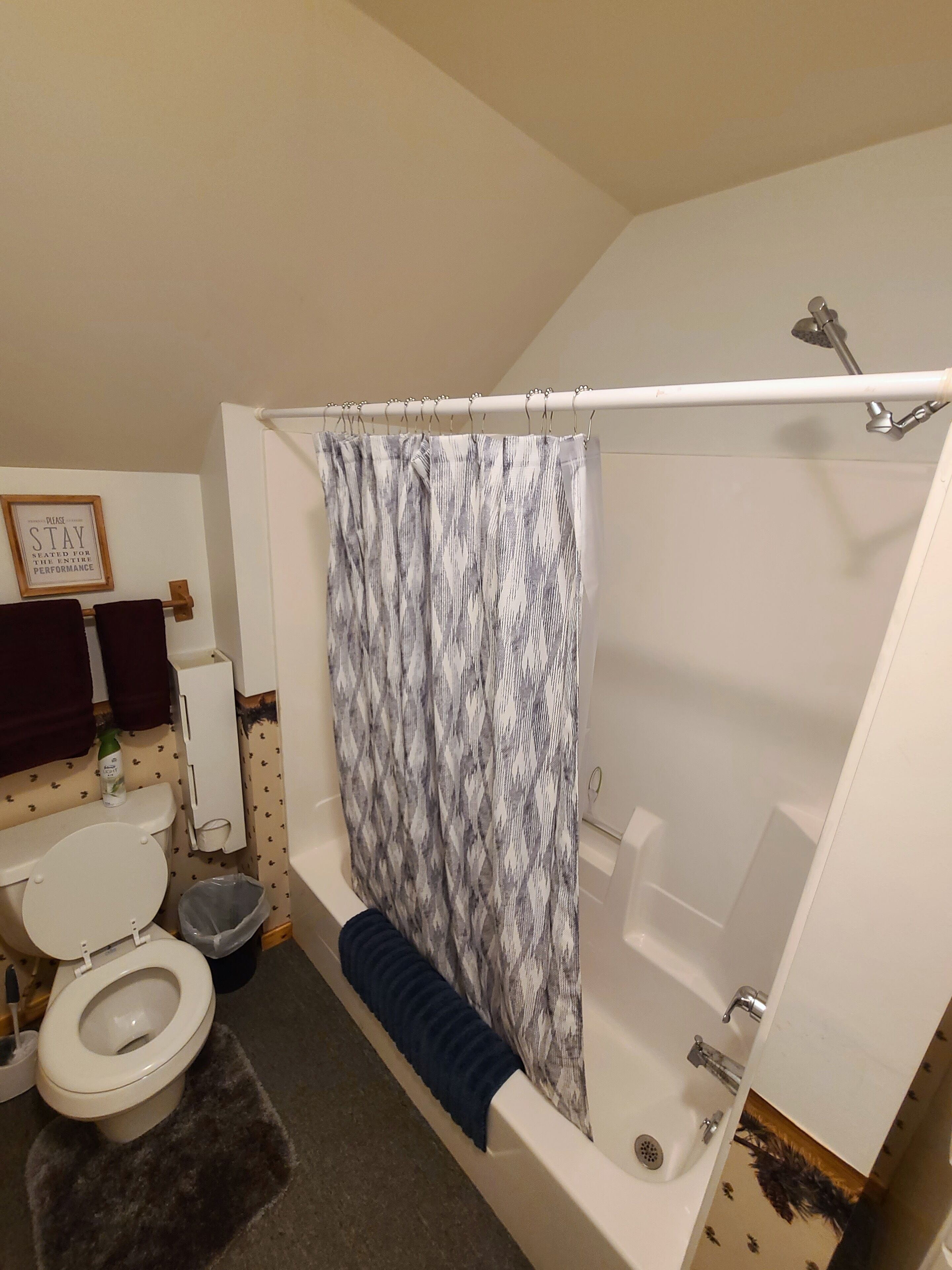 Un baño con una bañera blanca, una cortina de ducha, un inodoro y un lavabo.