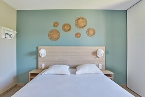 Un dormitorio con una cama, dos mesitas de noche, un cabecero y apliques de pared.