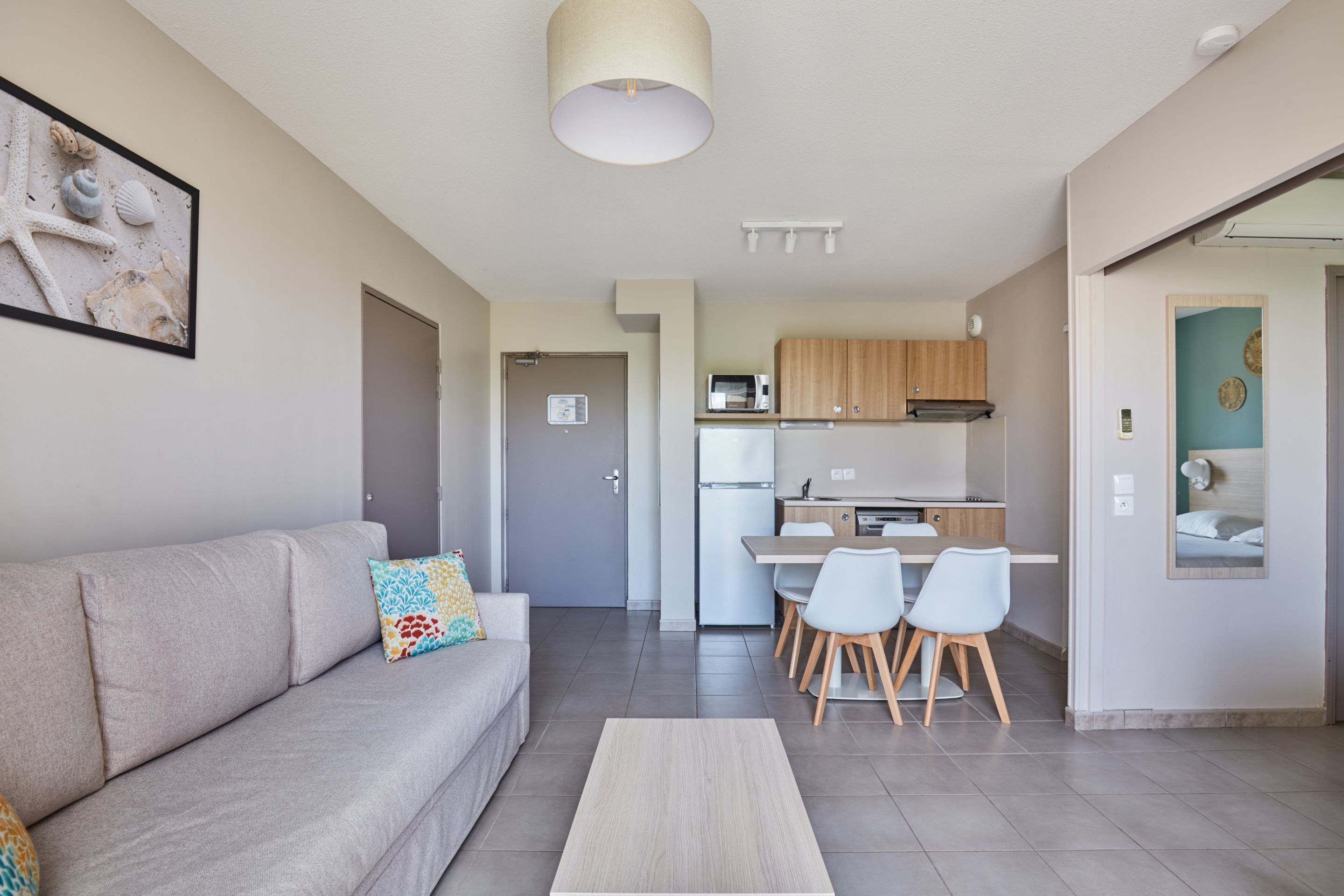 A modern apartment with a living room, kitchenette, and dining area.